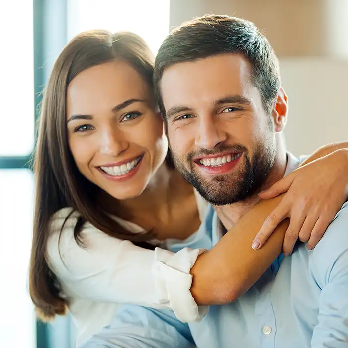 man and woman smiling together indoors